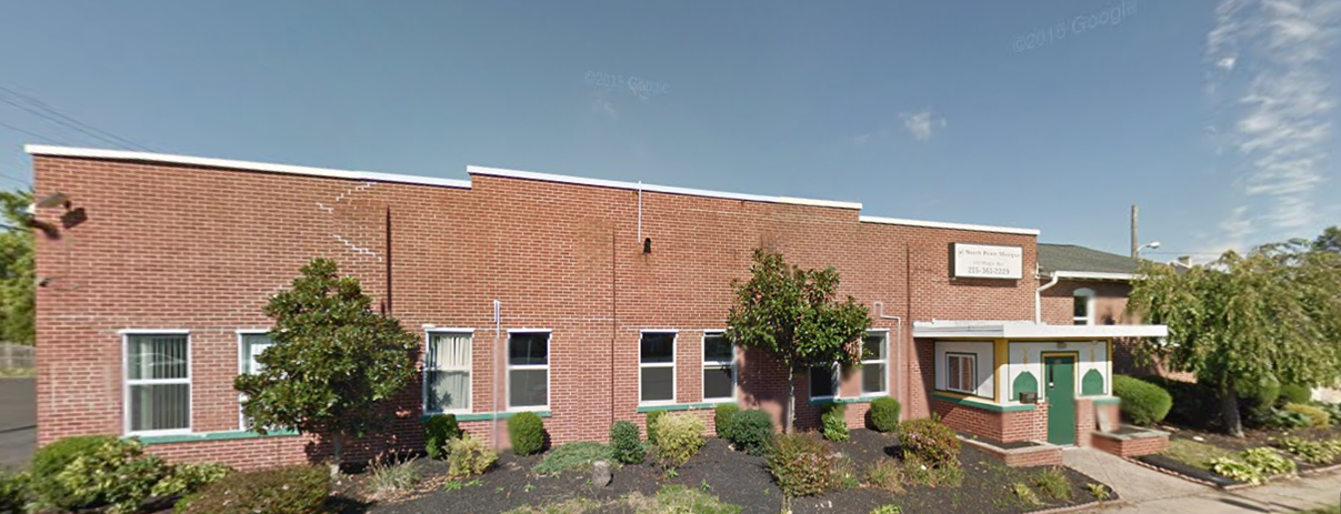 Single-story red brick building with shrubs